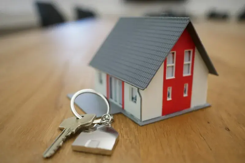 Miniature house model with a key ring on a timber table
