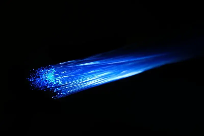 Strands of fibre optic cable glowing blue against a dark background
